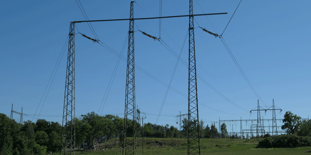 Högspänningsledning med blå himmel som bakgrund.