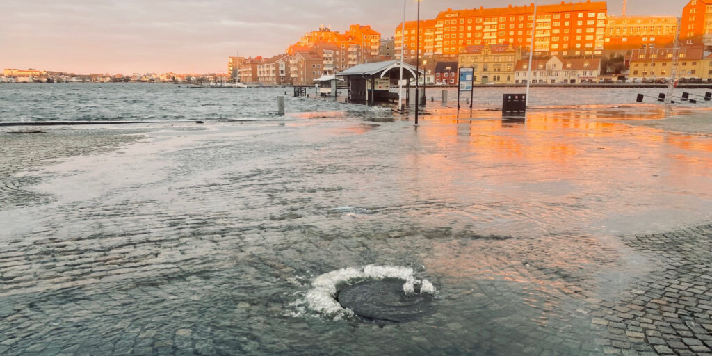 Översvämning vid Fisktorget Karlskrona, vatten kommer upp ur brunnslock.